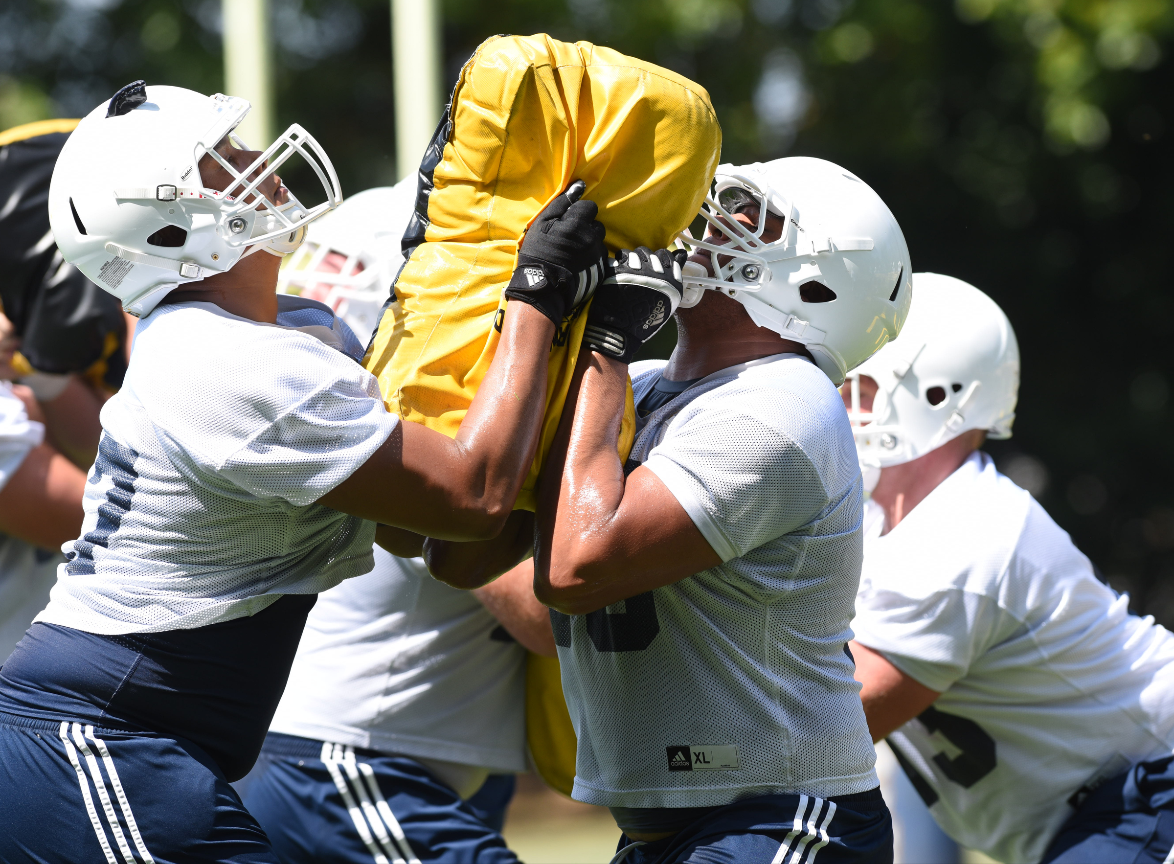 Mocs offensive linemen Kennington Cadwell (57), left, and Malcolm White (56), face off on the offensive line in a feet, hips and finish drill on the first day of Mocs football practice at Scrappy Moore Field.