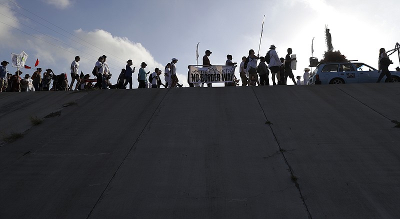 
              Hundreds of people march along a levee in South Texas toward the Rio Grande to oppose the wall the U.S. government wants to build on the river separating Texas and Mexico, Saturday, Aug. 12, 2017, in Mission, Texas. The area would be the target of new barrier construction under the Trump administration's current plan. (AP Photo/Eric Gay)
            