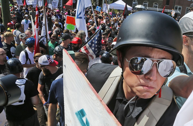 
              A white nationalist demonstrator with a helmet and shield walks into Lee Park in Charlottesville, Va., Saturday, Aug. 12, 2017.   Hundreds of people chanted, threw punches, hurled water bottles and unleashed chemical sprays on each other Saturday after violence erupted at a white nationalist rally in Virginia. At least one person was arrested.  (AP Photo/Steve Helber)
            