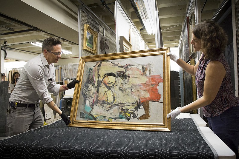 
              In this Aug. 9, 2017 photo provided by the University of Arizona, Willem de Kooning's "Woman-Ochre"  is readied for examination by Nathan Saxton, right, an exhibitions specialist, and Kristen Schmidt, a registrar, in Phoenix. More than three decades after thieves made off with the valuable painting from the University of Arizona Museum of Art, officials have recovered the long sought piece from an antique dealer in New Mexico.  (University of Arizona via AP)
            