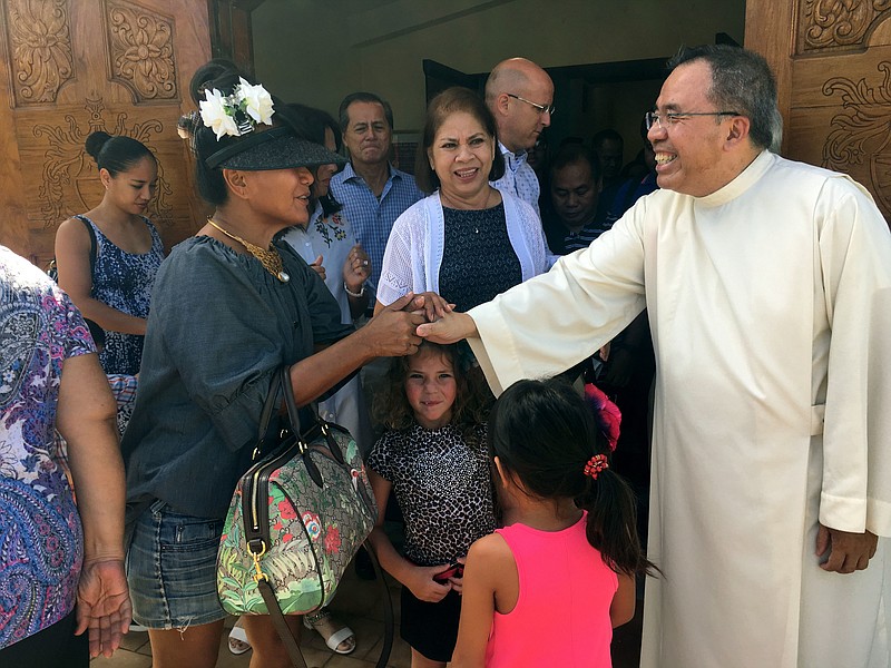 
              Pastor Fr. Jose Antonio" Lito" P. Abad, right, greets parishioners as they leave Blessed Diego de San Vitores Church following Sunday Mass, Sunday, Aug. 13, 2017, in Tumon, Guam. Across Guam - where nearly everyone is Roman Catholic - priests are praying for peace as residents of the U.S. Pacific island territory face a missile threat from North Korea. (AP Photo/Tassanee Vejpongsa)
            