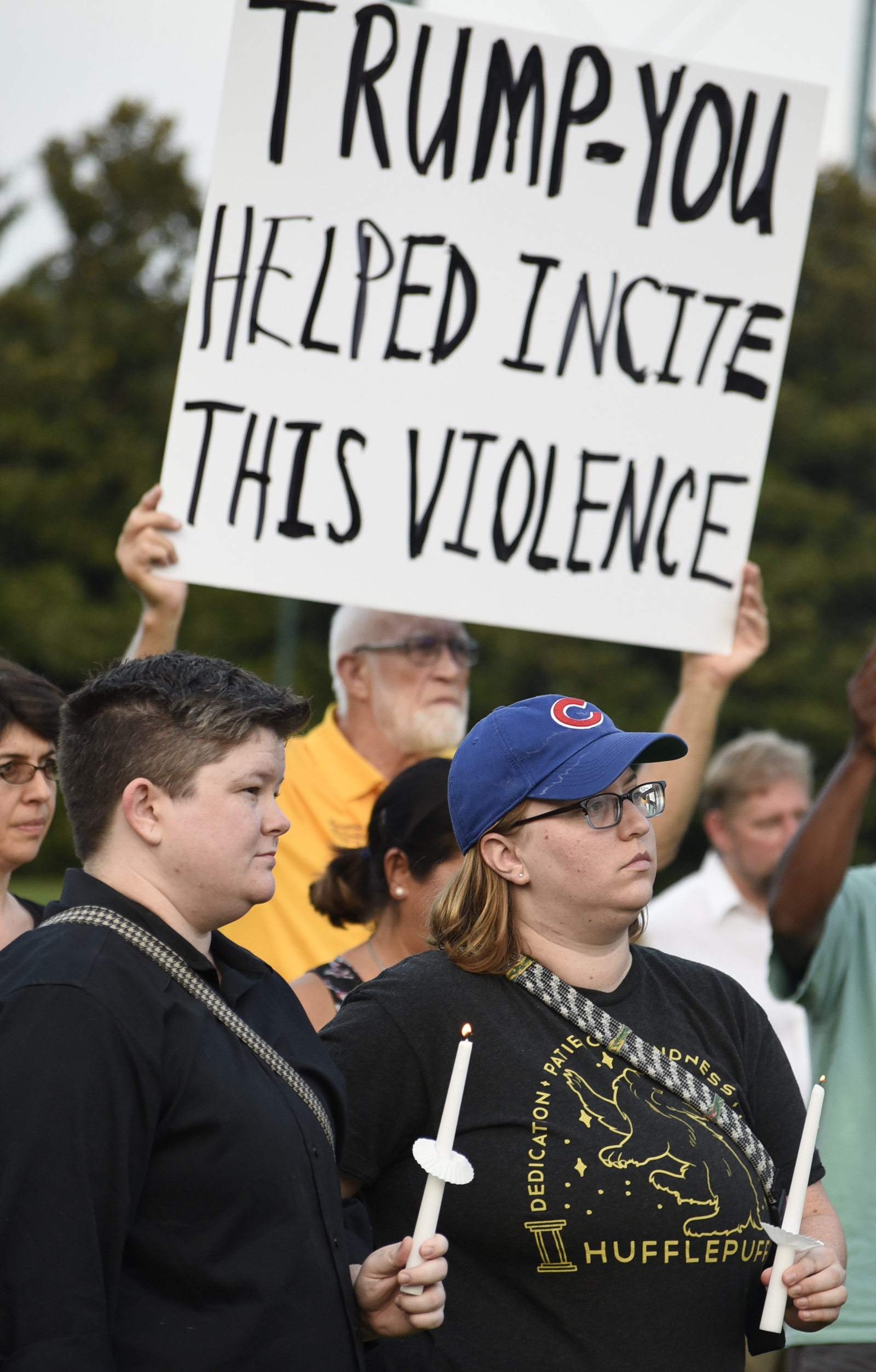 From left, Joel Willis and Becca Jones, of Chattanooga, hold candles during the vigil. In the background Franklin McCallie holds a sign denouncing President Donald Trump. The Chattanooga Democratic Socialists hosted a candlelight vigil for Heather Heyer and Charlottesville at Coolidge Park on August 13, 2017.