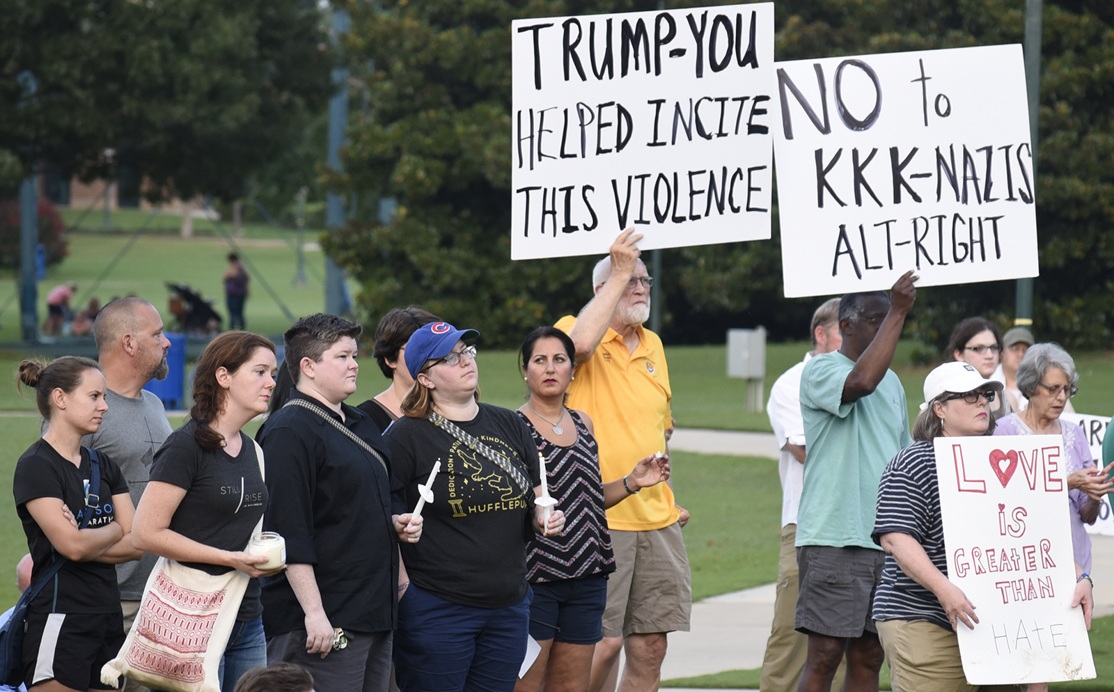 People listen to speakers, hold candles and display signs at a vigil remembering the recent violence in Charlottesville, Virginia. The Chattanooga Democratic Socialists hosted a candlelight vigil for Heather Heyer and Charlottesville at Coolidge Park on August 13, 2017.