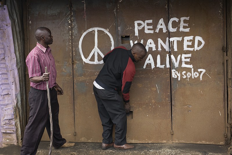 
              A Kenyan shopkeeper opens his store tagged with graffiti calling for peace in Nairobi's Kibera area Sunday Aug. 13, 2017.  The neighbourhood erupted into violence a day earlier as supporters of opposition leader Raila Odinga demonstrated after President Uhuru Kenyatta was declared victorious in Kenya's presidential election. (AP Photo/Jerome Delay)
            