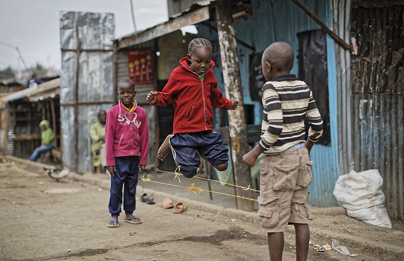 
              Young Kenyan children skip on the street inside the Mathare area of Nairobi, Kenya, Sunday, Aug. 13, 2017.  The Mathare area seems calm Sunday as pastors delivered Sunday Sermons following deadly post-election violence where rioters have battled police who fired live ammunition and tear gas.  (AP Photo/Ben Curtis)
            