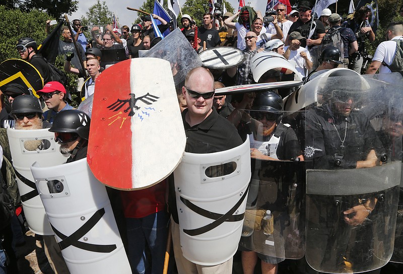 
              White nationalist demonstrators use shields as they guard the entrance to Lee Park in Charlottesville, Va., Saturday, Aug. 12, 2017. (AP Photo/Steve Helber)
            