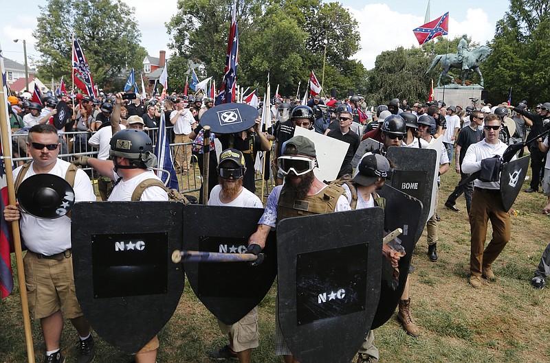 
              FILE - This Aug. 12, 2017 while photo shows white nationalist demonstrators holding their ground as they clash with counter demonstrators in Lee Park in Charlottesville, Va. Authorities have not provided a crowd estimate for the rally that descended into chaos. But two organizations that track hate groups and were monitoring the event said it was the largest white supremacist gathering in a decade or more. (AP Photo/Steve Helber)
            