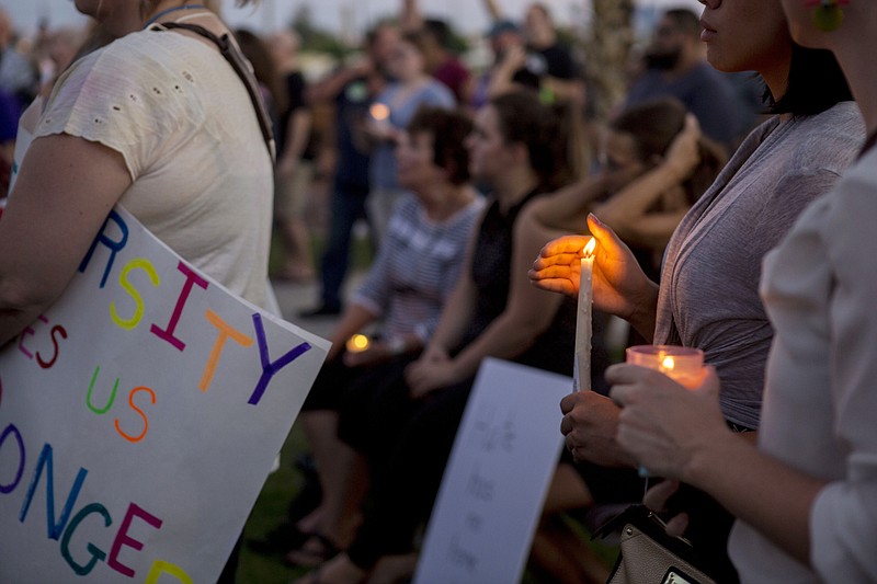 
              Candles are held during a vigil for victims in Charlottesville, Va., at the Rev. Dr. Martin Luther King Jr., Memorial Statue in North Las Vegas, Nev., Sunday, Aug. 13, 2017. Protesters decrying hatred and racism converged around the country on Sunday, saying they felt compelled to counteract the white supremacist rally that spiraled into deadly violence in Virginia. (Elizabeth Brumley/Las Vegas Review-Journal via AP)
            