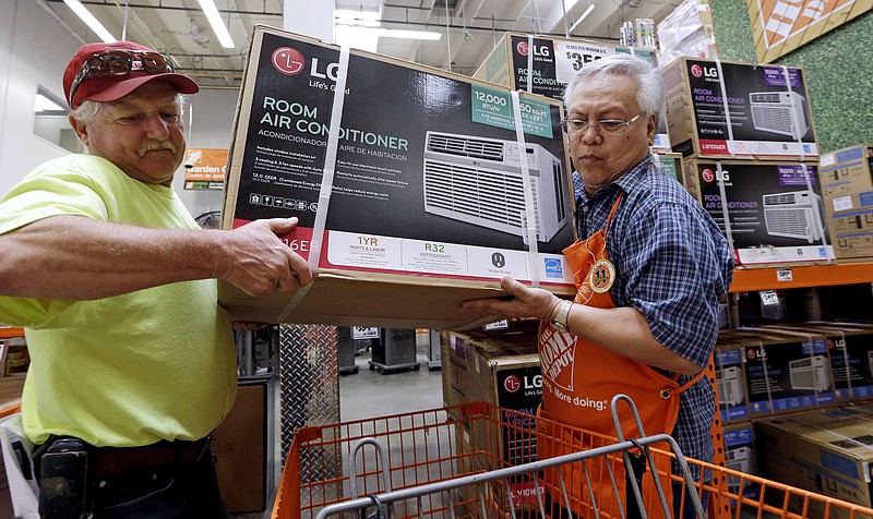 
              FILE - In this Tuesday, Aug. 1, 2017, file photo, store greeter Danny Olivar, right, lends a hand to a customer, who declined to be identified, to heft an air conditioning unit from a rapidly declining stock at a Home Depot store ahead of an expected heat wave in Seattle. The Home Depot Inc. reports earnings Tuesday, Aug. 15, 2017. (AP Photo/Elaine Thompson, File)
            