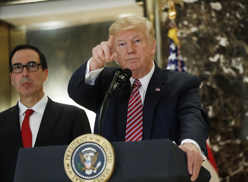 President Donald Trump, accompanied by Treasury Secretary Steven Mnuchin, calls on a reporter while meeting the media in the lobby of Trump Tower in New York, Tuesday, Aug. 15, 2017. (AP Photo/Pablo Martinez Monsivais)