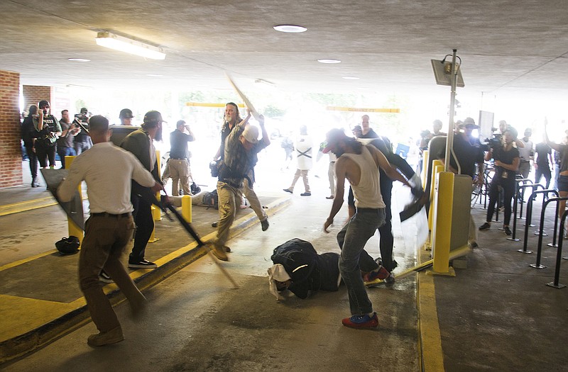
              In this Saturday, Aug. 12, 2017 photo, DeAndre Harris, bottom is assaulted in a parking garage beside the Charlottesville police station after a white nationalist rally was disbursed by police, in Charlottesville, Va. (Zach D. Roberts via AP)
            
