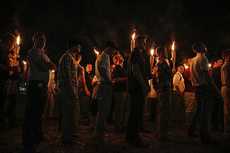 
              In this Friday, Aug. 11, 2017 photo, multiple white nationalist groups march with torches through the UVA campus in Charlottesville, Va. W.C. Bradley Co. President and CEO Marc Olivie told the Columbus Ledger-Enquirer on Monday, Aug. 14 that the Columbus-based company’s staff was “appalled and saddened” that its Tiki brand torches were “used by people who promote bigotry and hatred.” (Mykal McEldowney/The Indianapolis Star via AP)
            