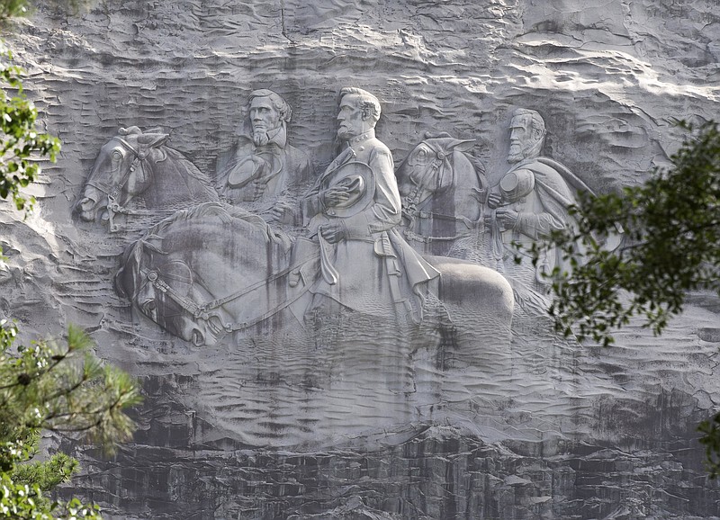 
              FILE - This June 23, 2015, file photo shows a carving depicting confederates Stonewall Jackson, Robert E. Lee and Jefferson Davis, in Stone Mountain, Ga. Democratic front-runner for governor Stacey Abrams posted several tweets Tuesday, Aug. 15, 2017, saying the carving at the tourist attraction Stone Mountain Park and other Confederate statues and monuments around the state should be removed. (AP Photo/John Bazemore, File)
            