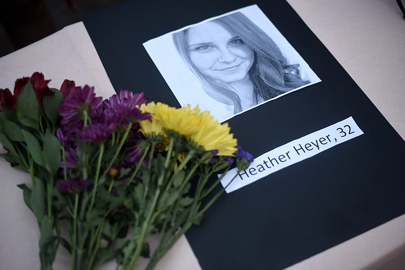 
              A portrait of Heather Heyer, who was killed when a vehicle drove through counter protestors in Charlottesville, Va., lies on a table with flowers during a vigil on the campus of the University of Southern Mississippi in Hattiesburg, Miss., Monday, Aug 14, 2017. The rally was held in response to a white nationalist rally held in Charlottesville, Va., over the weekend. (Courtland Wells/The Vicksburg Post via AP)
            