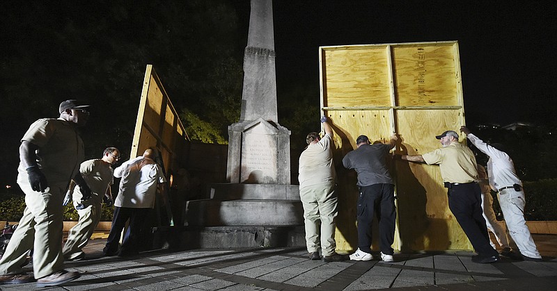 Birmingham city workers use plywood panels to cover the Confederate Monument in Linn Park, in Birmingham, Ala., Tuesday night, Aug. 15, 2017, on orders from Mayor William Bell. (Joe Songer /AL.com via AP)

