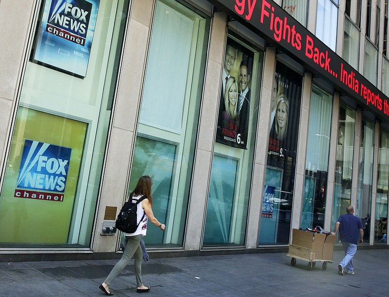 
              FILE- In this Aug. 1, 2017, file photo, people pass the News Corporation headquarters building and Fox News studios in New York. A Fox News Channel anchor whose reaction to President Donald Trump's comments on Charlottesville spread widely says she feels threatened but not deterred after a flood of angry responses from viewers to her words. Kat Timpf, of the Fox show "The Specialists," said Wednesday, Aug. 16, that she's blocked part of her Twitter feed and stopped looking at emails. A day earlier, Timpf called Trump’s news conference disgusting and said "I have too much eye makeup on to cry right now."(AP Photo/Richard Drew, File)
            