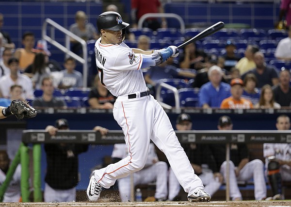 FILE - Clockwise from top left are 2017 file photos showing: Miami Marlins' Giancarlo  Stanton hitting a two-run home run during the third inning against the  Washington Nationals in Washington; Giancarlo Stanton