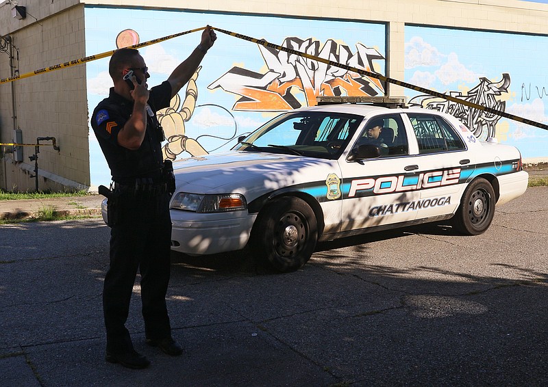 A Chattanooga police officer raises crime scene tape for another officer to leave Wednesday, Aug. 16, 2017, at a crime scene on Oakland Avenue at 43rd Street in Chattanooga, Tenn. A man was shot in the 4300 block of Oakland Avenue and sustained injuries that were not life-threatening.