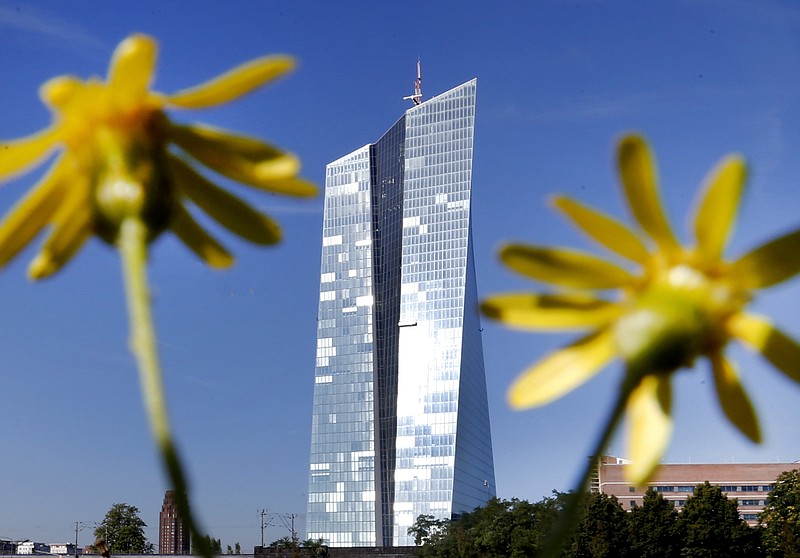 
              FILE - In this Sept. 7,2016 file photo the headquarters of the European Central Bank is seen through flowers in Frankfurt, Germany. Germany's top court has declined to hear a series of challenges to the European Central Bank's bond-buying stimulus program, referring them instead to the European Court of Justice. The dpa news agency reports Tuesday Aug. 15, 2017 that those against the program claimed it constituted illegal budget financing and that Germany's central bank should not be participating.  (AP Photo/Michael Probst,file)
            