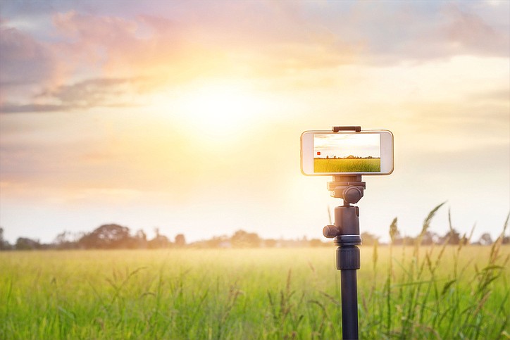 Set up a tripod and your phone's camera to take a time-lapse photo series of the scenery as the light dims.