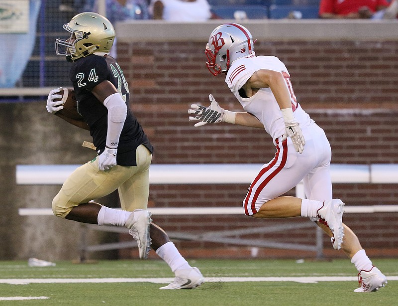 Notre Dame's Akil Sledge (24) runs for one of his two touchdowns, while chased by Baylor's Jay Mosier in the area football season opener Thursday at Finley Stadium.