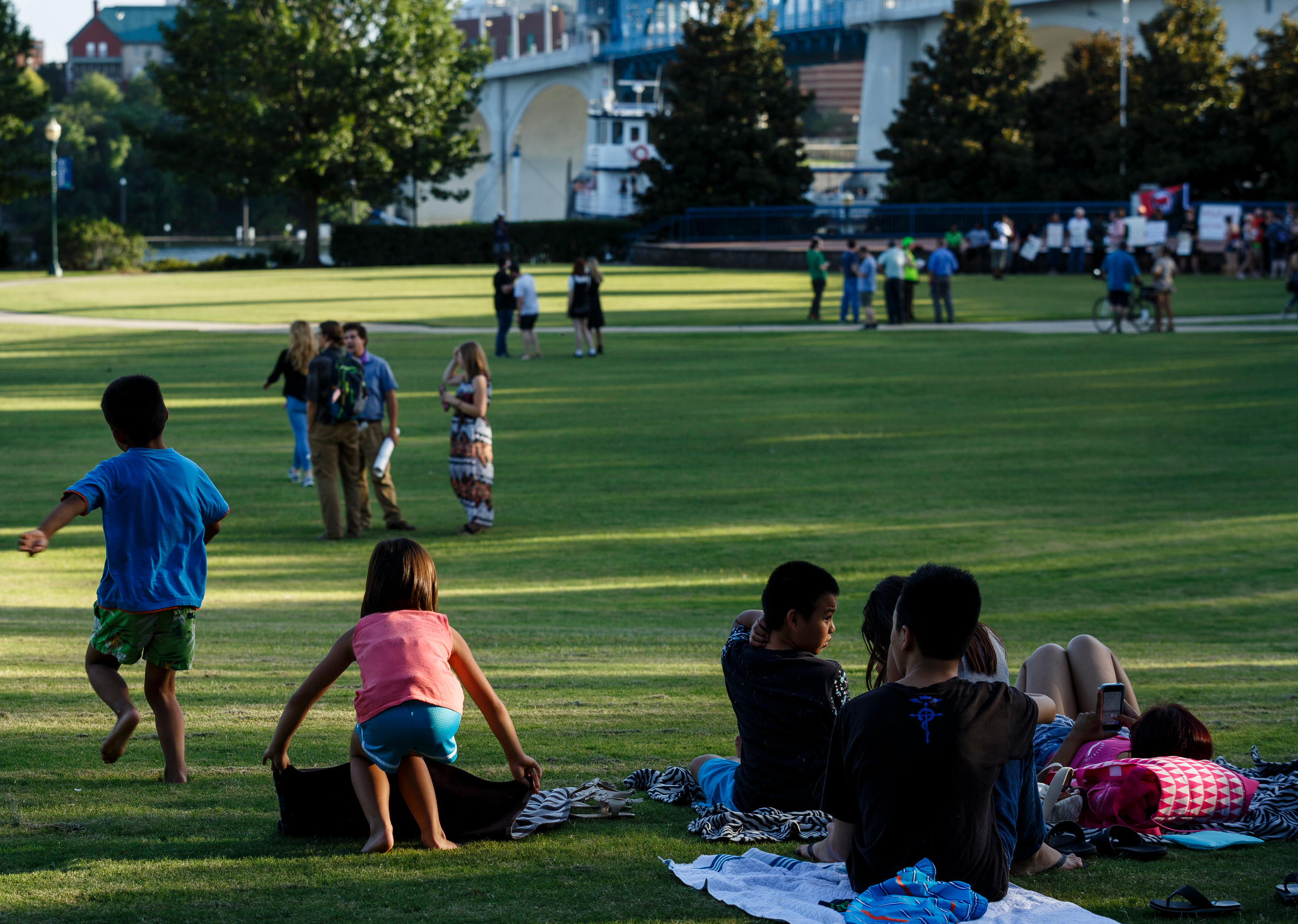 Families lay out blankets as demonstrators assemble for a "Declaration of Resistance" rally in Coolidge Park on Thursday, Aug. 17, 2017, in Chattanooga, Tenn. Organizers said that the purpose of the demonstration, held in response to violence at the "Unite the Right" rally in Charlottesville, Va., was to declare resistance against Nazism.