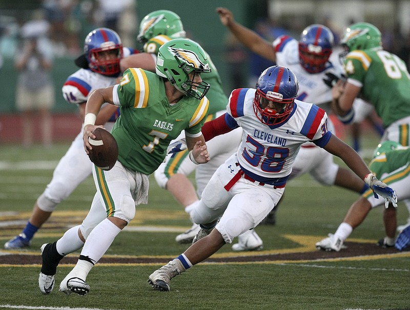 Rhea County quarterback Zack Pemberton scrambles under pressure from Cleveland's Dre Goodwin during a game last season. Pemberton's return as a fourth-year starter is a big plus for Rhea County.