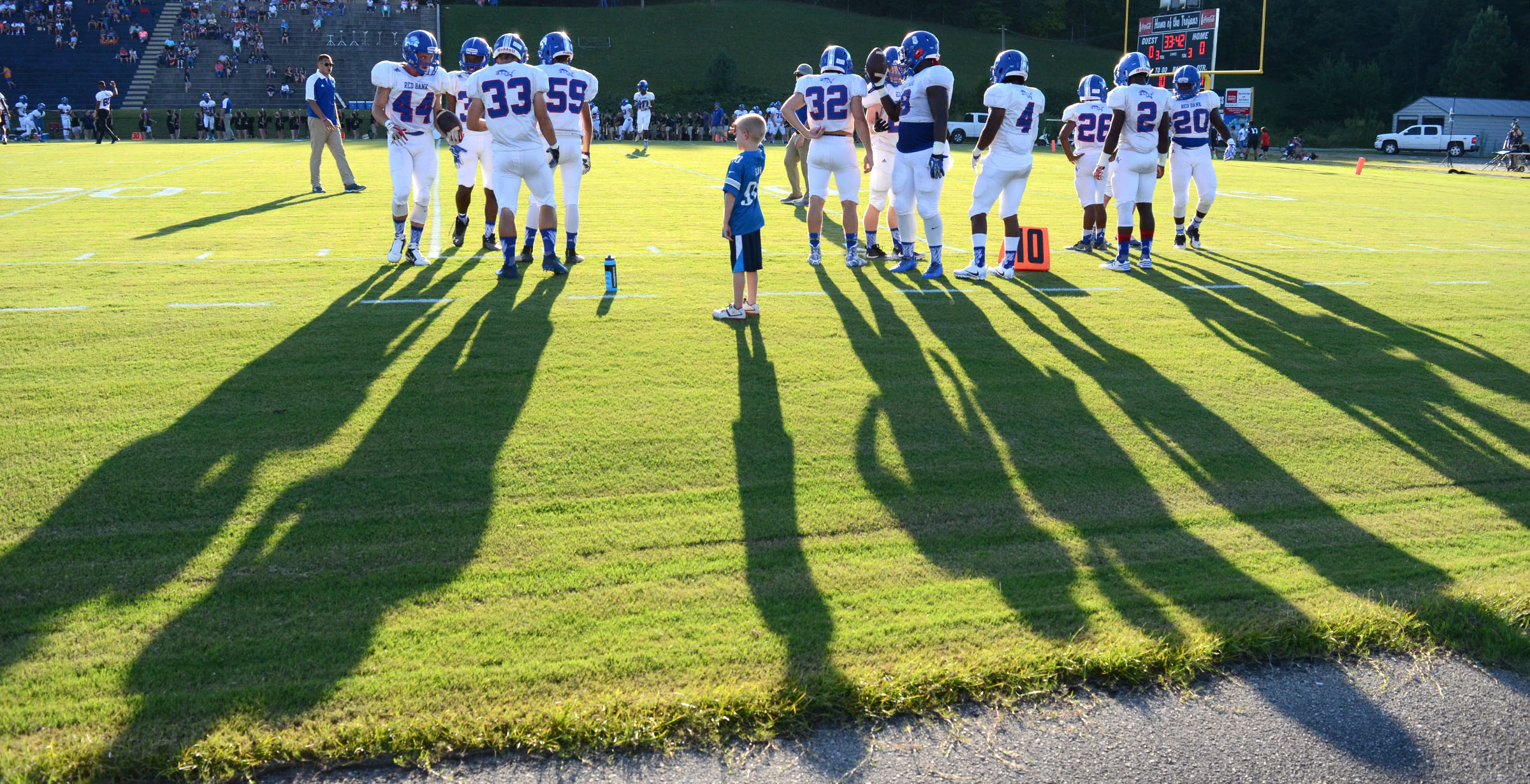 A young fan's shadow casts almost as large as his Red Bank Lions heros warm up before the game.. The Red Bank Lions visited the Soddy-Daisy Trojans in TSSAA football action at Soddy-Daisy High School on August 18, 2017.