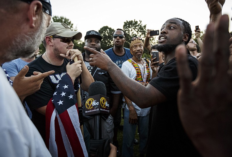 
              Isaiah Moore, right, argues with counter demonstrators about race relations during a rally in Coolidge Park on Thursday, Aug. 17, 2017, in Chattanooga, Tenn. Organizers said that the purpose of the demonstration, held in response to Saturday's rally by white nationalists in Charlottesville, Va., was to declare resistance against Nazism. (Doug Strickland/Chattanooga Times Free Press via AP)
            