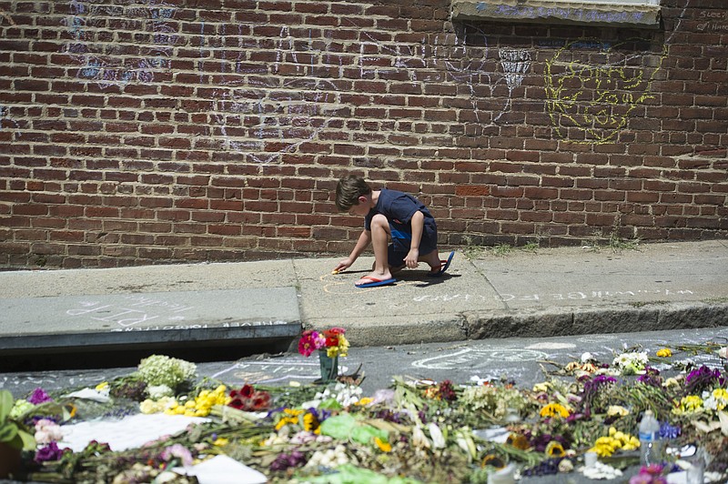 
              Alexander Holtz, 7, of Ashburn, Va., draws a heart on sidewalk in Charlottesville, Va., Friday, Aug. 18, 2017, near the site where Heather Heyer was killed. Heyer was struck by a car while protesting a white nationalist rally on Saturday Aug. 12. (AP Photo/Cliff Owen)
            
