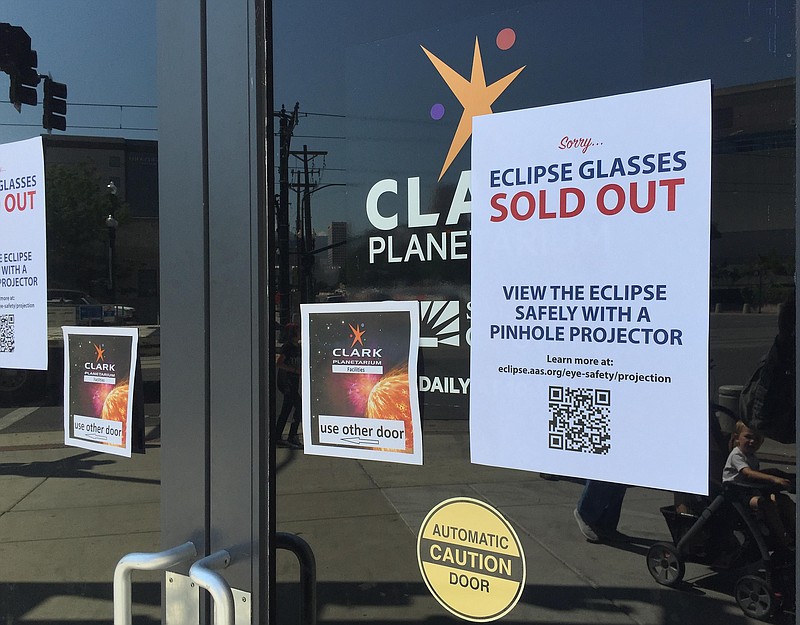 
              An eclipse glasses sold out sign is posted outside the Clark Planetarium main doors advising people to safely view the eclipse with a pinhole projector after the planetarium ran out of glasses Thursday, Aug. 17, 2017, in Salt Lake City. (AP Photo/Brady McCombs)
            