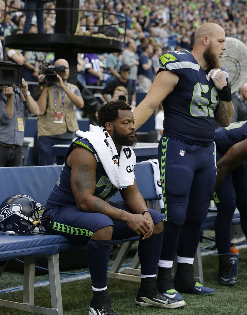 
              Seattle Seahawks center Justin Britt, right, stands next to defensive end Michael Bennett as Bennett sits on the bench during the singing of the national anthem before the team's NFL football preseason game against the Minnesota Vikings, Friday, Aug. 18, 2017, in Seattle. (AP Photo/Stephen Brashear)
            