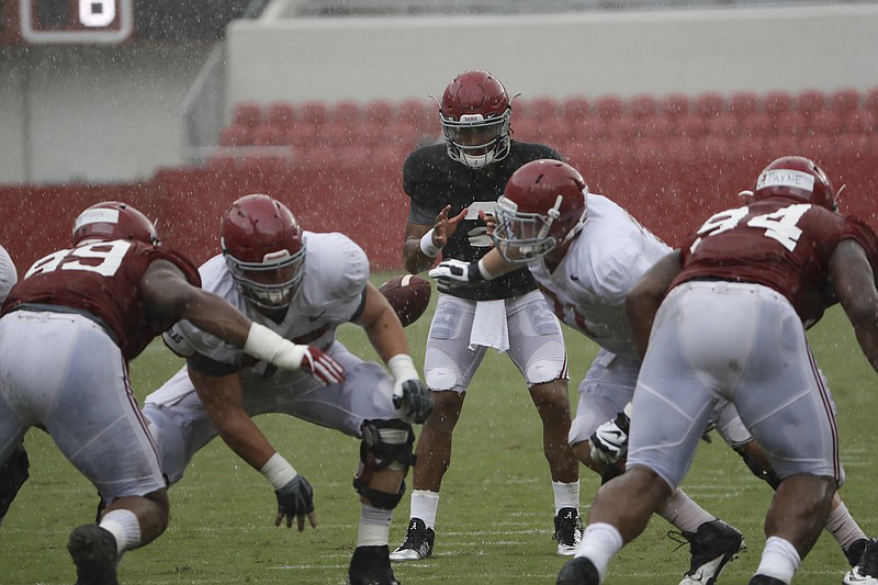 Alabama quarterback Jalen Hurts takes a snap from center Bradley Bozeman (75) during Saturday's scrimmage that was briefly halted by rain.