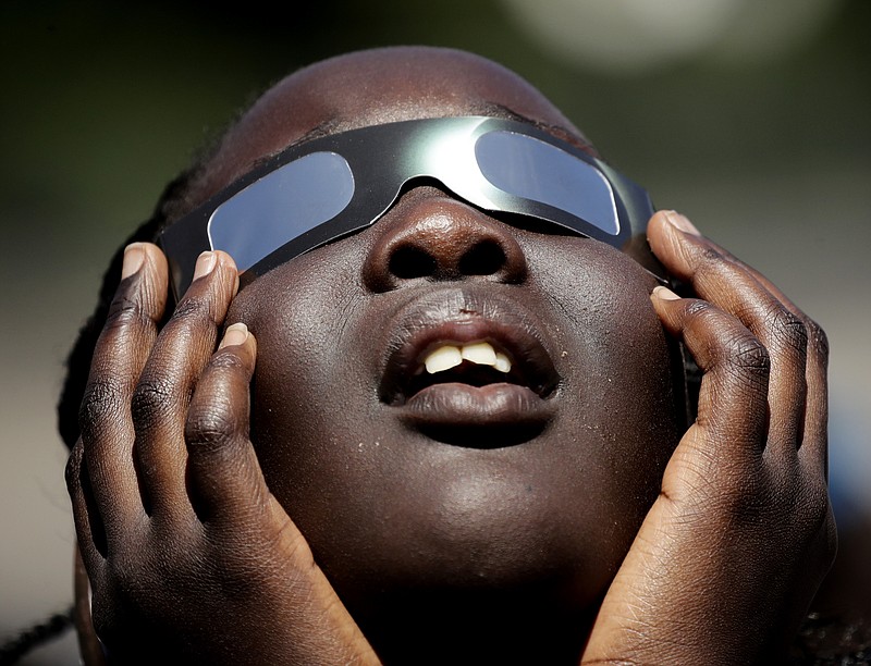 
              In this photo taken Friday, Aug. 18, 2017, Poureal Long, a fourth grader at Clardy Elementary School in Kansas City, Mo., practices the proper use of eclipse glasses in anticipation of Monday's solar eclipse.  Schools around the country preparing for the solar eclipse are reacting in a variety ways, with some using the event for a full day of science lessons and others closing to avoid the crush of crowds expected in their towns. (AP Photo/Charlie Riedel)
            