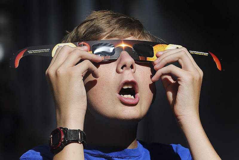 
              FILE - In this Wednesday, Aug. 16, 2017 photo, Colton Hammer tries out his new eclipse glasses he just bought from the Clark Planetarium in Salt Lake City in preparation for the Aug. 21 eclipse. Eye doctors urge strict adult supervision for eclipse watchers under 16 years old.
 (Scott G Winterton/The Deseret News via AP)
            