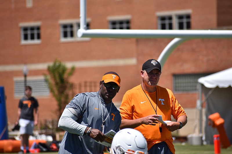 Tennessee secondary coach Charlton Warren, left, and defensive coordinator Bob Shoop look on as Tennessee's players stretch before practice on July 30, 2017. 

