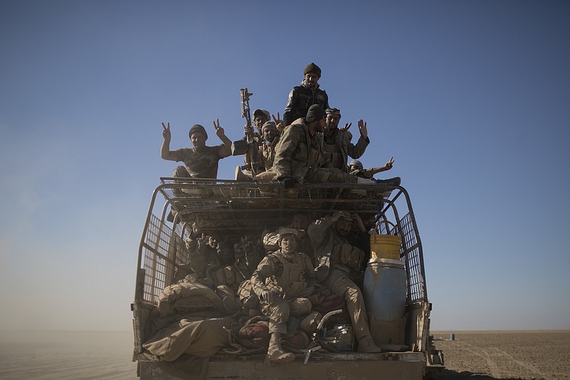 
              FILE - In this Nov. 20, 2016 file photo, Popular Mobilization Units fighters ride on the back of a truck on their way to fight against Islamic State militants in the airport of Tal Afar, west of Mosul, Iraq. The operation to retake the town of Tal Afar, west of Mosul, from the Islamic State group began Sunday morning, Aug. 20, 2017,  Iraq's prime minister said. Tal Afar and the surrounding area is one of the last pockets of IS-held territory in Iraq after victory was declared in July in Mosul, the country's second-largest city. The town, about 150 kilometers (93 miles) east of the Syrian border, sits along a major road that was once a key IS supply route.(AP Photo/Felipe Dana, File)
            