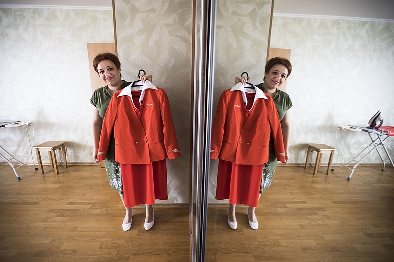 
              In this photo taken on Thursday, Aug. 3, 2017, Aeroflot flight attendant Yevgeniya Magurina is reflected in a mirror as she shows her uniform during an interview with the Associated Press in Lobnya, outside Moscow, Russia. The Moscow City Court is to due to rule in the case of two flight attendants who are suing Russia's flagship airline for taking them off the prestigious long-haul flights because of their looks. (AP Photo/Alexander Zemlianichenko)
            