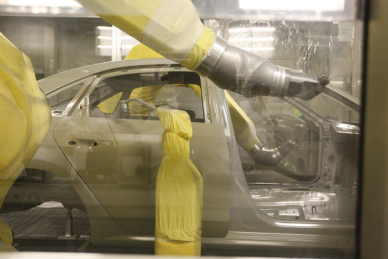 Robotic arms spray paint onto the body of a Passat on in the paint shop of the Chattanooga Volkswagen Plant.