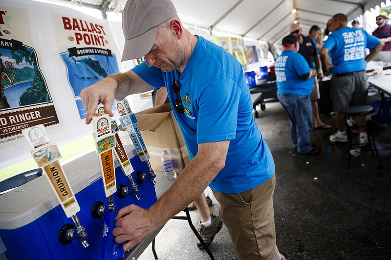 Jeremy Ames fills a beer for a customer at the Southern Brewers Festival at Ross's Landing on Saturday, Aug. 20, 2016, in Chattanooga, Tenn. The craft beer festival benefits nonprofits like Kids on the Block.