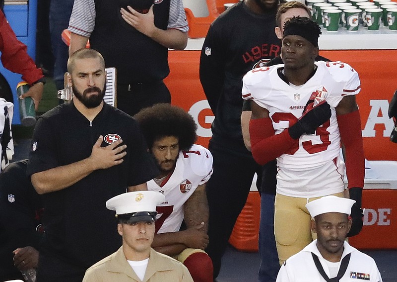 San Francisco 49ers quarterback Colin Kaepernick, center, kneels during the national anthem before the team's final NFL preseason football game during the 2016 season.