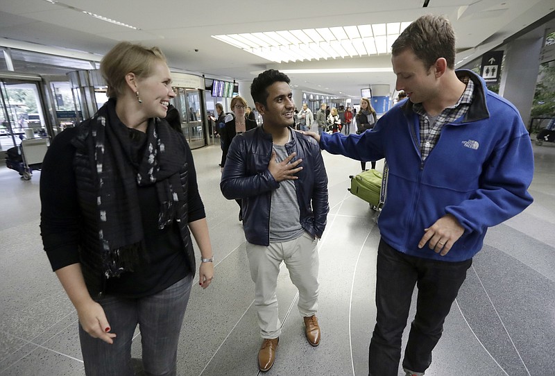 
              FILE- In this Feb. 8, 2017, file photo, Army Capt. Matthew Ball, right, walks with his former interpreter Qismat Amin, center, alongside Ball's wife, Giselle Rahn, after Amin arrived from Afghanistan at San Francisco International Airport in San Francisco. Amin, who worked as a translator for the US military in Afghanistan from 2010 to 2015 and now lives in Fremont, Calif., said the Trump administration's strategy outlines what every Afghan wants to hear--that the U.S. will continue having a military presence until there is stability in the country. (AP Photo/Marcio Jose Sanchez, File)
            