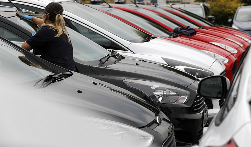 
              A worker cleans cars that are on display at a Ford car forecourt in London, Tuesday, Aug. 22, 2017.  A Ford emblem is seen on a car at a store in London, Tuesday, Aug. 22, 2017.  Car manufacturer Ford is offering car buyers in Britain a 2,000-pound (US dlrs 2,570) incentive to trade in older vehicles for new, less polluting models.(AP Photo/Frank Augstein)
            