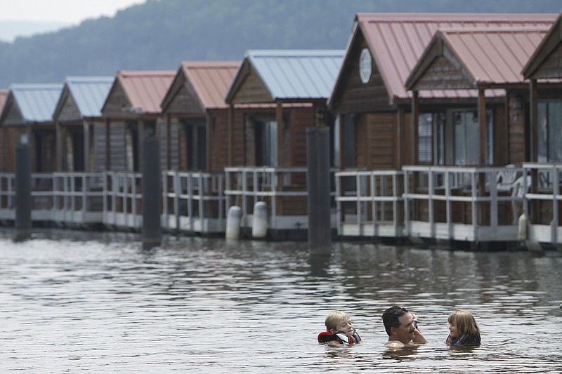 Chattanooga resident David Seymore swims with his children Ethan Seymore, left, and Katelyn Seymore, right, behind one of the floating condos he rented at Hales Bar Marina.