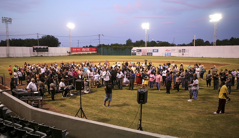 People gather on the field during a community-wide prayer event at Historic Engel Stadium on Wednesday, Aug. 23, in Chattanooga, Tenn. Members of various churches in the Chattanooga area gathered to pray amid rising racial tensions, threats of war abroad and local shootings.