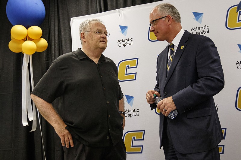 New UTC athletic director Mark Wharton, right, talks with women's basketball coach Jim Foster on Wednesday. Wharton was introduced during a news conference at the University Center.