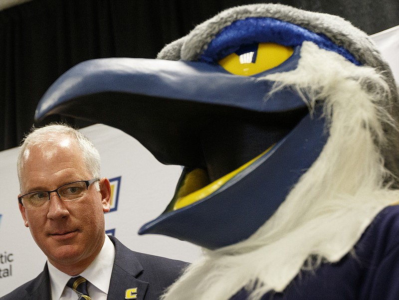 New UTC athletic director Mark Wharton meets Mocs mascot Scrappy after Wharton's introductory news conference Wednesday.