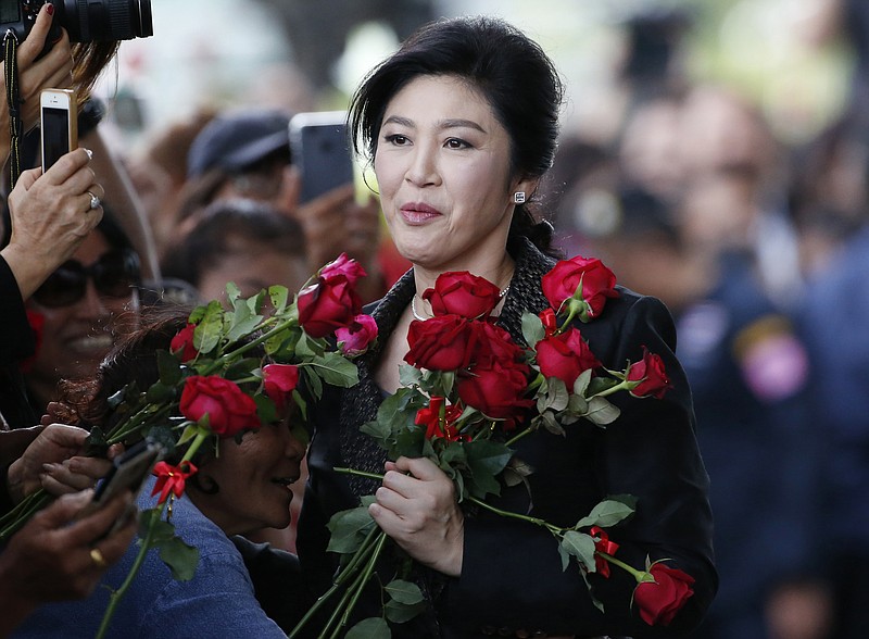 
              In this Aug. 1, 2017 photo, Thailand's former Prime Minister Yingluck Shinawatra receives flowers from her supporters on her arrival at the Supreme Court to make final statement of the hearing in Bangkok, Thailand. Friends and foes alike of Yingluck Shinawatra, are anxiously awaiting a verdict Friday, Aug. 25, 2017 by the country's Supreme Court on charges that she was criminally negligent in implementing a rice subsidy program that is estimated to have cost the government as much as $17 billion and could now cost her 10 years in prison. (AP Photo/Sakchai Lalit)
            