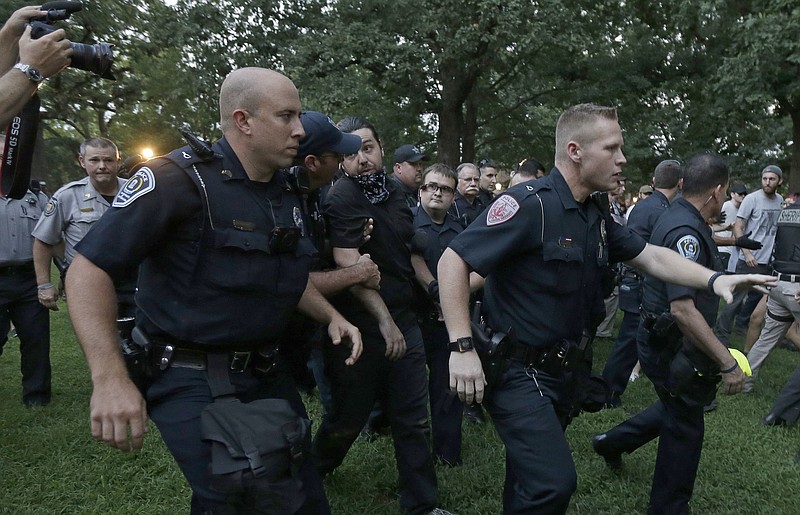 
              Police arrest a man during a protest at a Confederate monument at the University of North Carolina in Chapel Hill, N.C., Tuesday, Aug. 22, 2017. The gathering Tuesday night at the university focused on a statue known as "silent Sam." People chanted "tear it down" while uniformed officers watched from behind temporary metal barriers ringing the statue, depicting a Confederate soldier. (AP Photo/Gerry Broome)
            