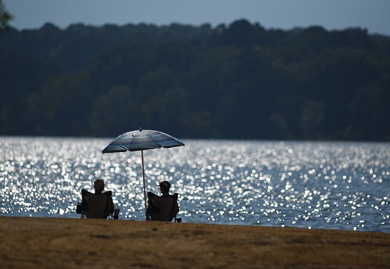 Dan and Deb Harrison, of Flanagan, Ill., rest under their beach umbrella at Chester Frost Park late Tuesday, Aug. 22.